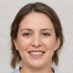 Joyful white young-adult female with medium  brown hair and grey eyes