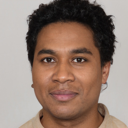 Joyful black young-adult male with short  black hair and brown eyes