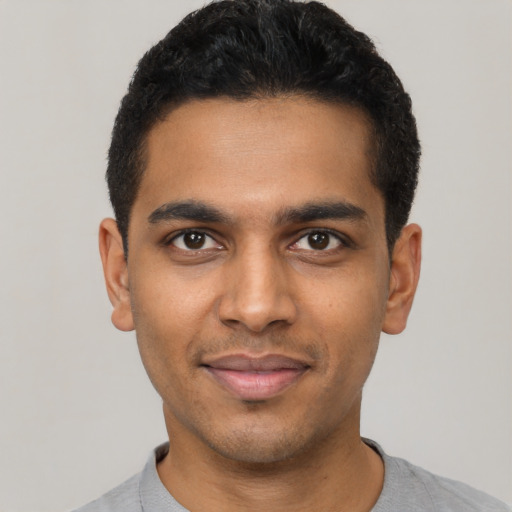 Joyful latino young-adult male with short  black hair and brown eyes