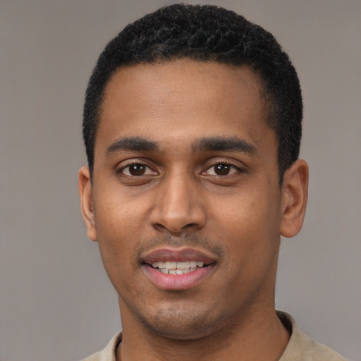 Joyful black young-adult male with short  black hair and brown eyes