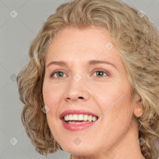 Joyful white young-adult female with medium  brown hair and green eyes