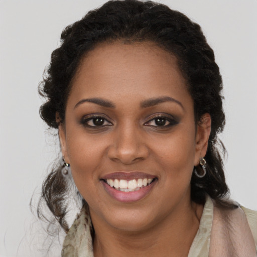 Joyful black young-adult female with long  brown hair and brown eyes