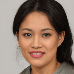 Joyful latino young-adult female with medium  brown hair and brown eyes