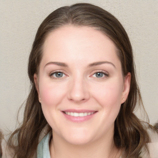 Joyful white young-adult female with long  brown hair and blue eyes