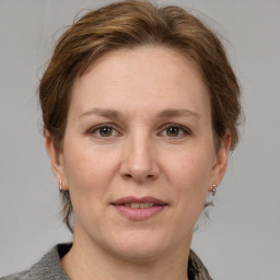 Joyful white adult female with medium  brown hair and grey eyes