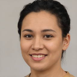 Joyful latino young-adult female with medium  brown hair and brown eyes