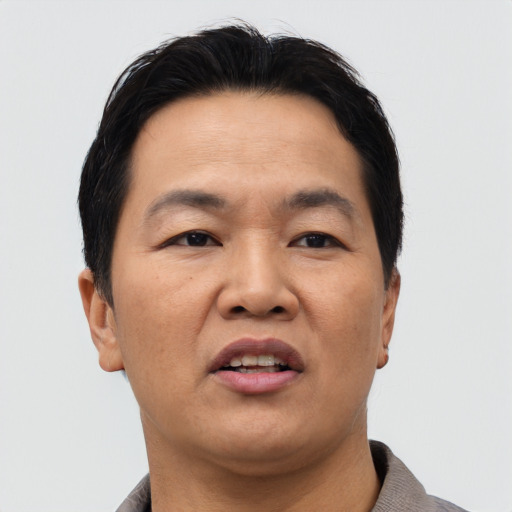 Joyful asian adult male with short  brown hair and brown eyes