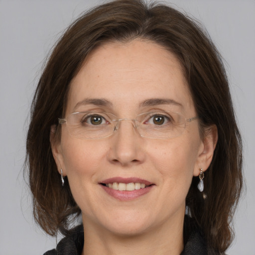 Joyful white adult female with medium  brown hair and grey eyes