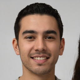 Joyful white young-adult male with short  black hair and brown eyes