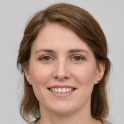 Joyful white young-adult female with medium  brown hair and grey eyes