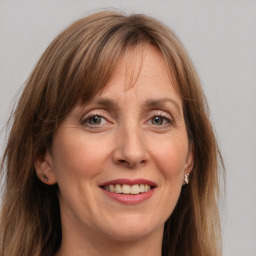 Joyful white adult female with long  brown hair and grey eyes