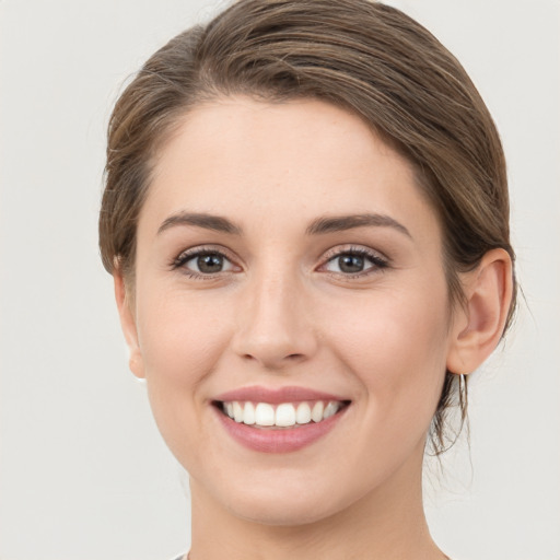 Joyful white young-adult female with medium  brown hair and grey eyes