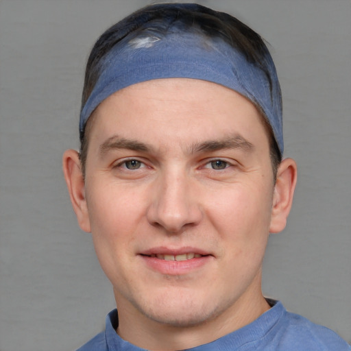 Joyful white young-adult male with short  brown hair and blue eyes