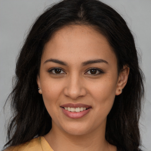 Joyful latino young-adult female with long  brown hair and brown eyes