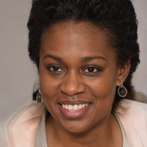 Joyful black young-adult female with short  brown hair and brown eyes