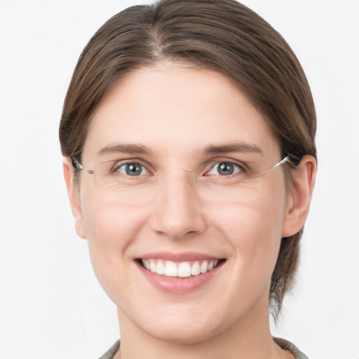 Joyful white young-adult female with medium  brown hair and grey eyes