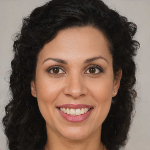 Joyful latino young-adult female with long  brown hair and brown eyes