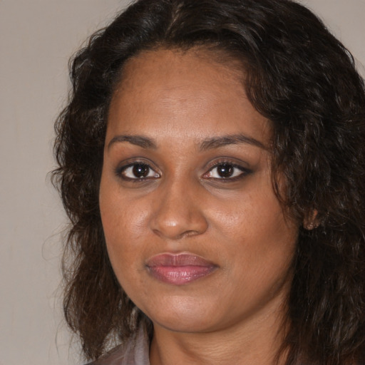 Joyful black young-adult female with long  brown hair and brown eyes