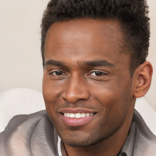 Joyful black young-adult male with short  brown hair and brown eyes