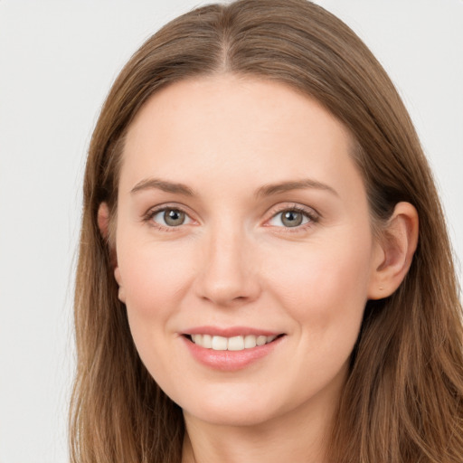 Joyful white young-adult female with long  brown hair and grey eyes