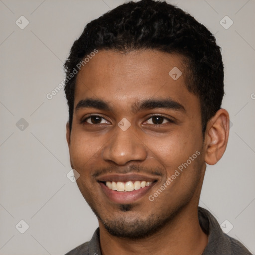 Joyful black young-adult male with short  black hair and brown eyes