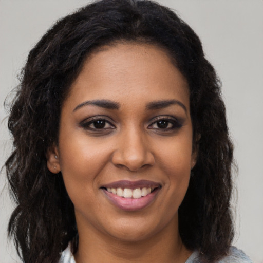 Joyful black young-adult female with long  brown hair and brown eyes