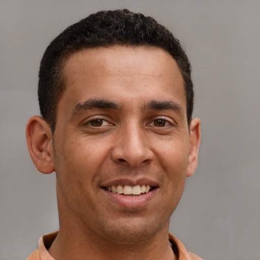 Joyful latino young-adult male with short  brown hair and brown eyes