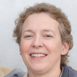 Joyful white adult female with medium  brown hair and blue eyes