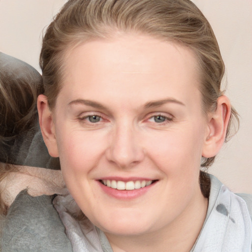 Joyful white adult female with medium  brown hair and blue eyes