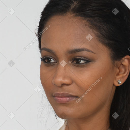 Joyful black young-adult female with long  brown hair and brown eyes