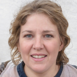 Joyful white adult female with medium  brown hair and blue eyes