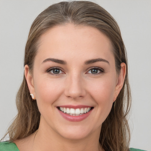 Joyful white young-adult female with long  brown hair and grey eyes