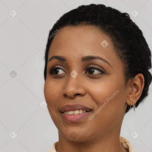 Joyful black young-adult female with short  black hair and brown eyes