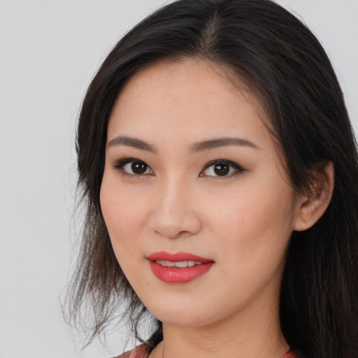 Joyful asian young-adult female with long  brown hair and brown eyes