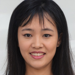 Joyful asian young-adult female with long  brown hair and brown eyes