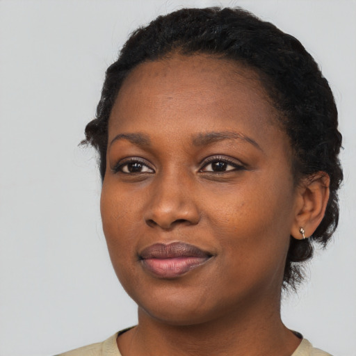 Joyful black young-adult female with short  black hair and brown eyes