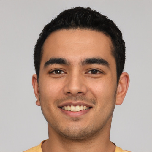 Joyful latino young-adult male with short  black hair and brown eyes