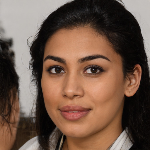 Joyful latino young-adult female with medium  brown hair and brown eyes