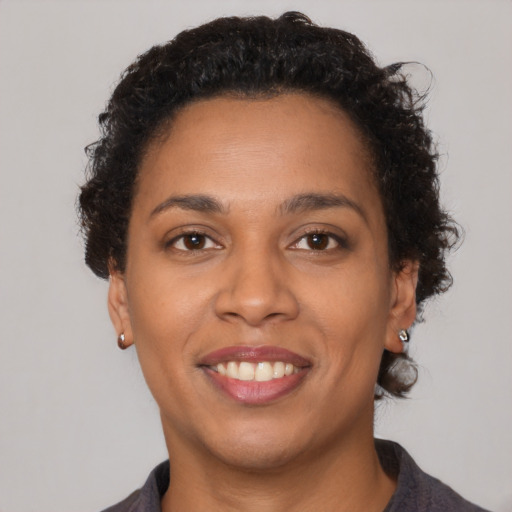 Joyful black young-adult female with medium  brown hair and brown eyes
