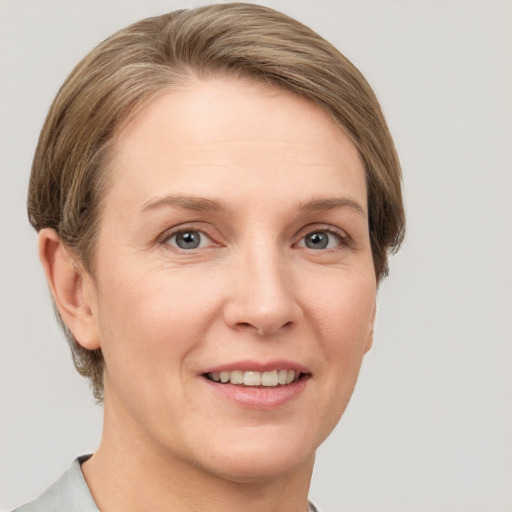 Joyful white adult female with short  brown hair and grey eyes