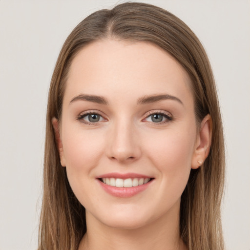 Joyful white young-adult female with long  brown hair and grey eyes