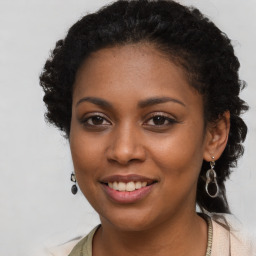 Joyful black young-adult female with long  brown hair and brown eyes