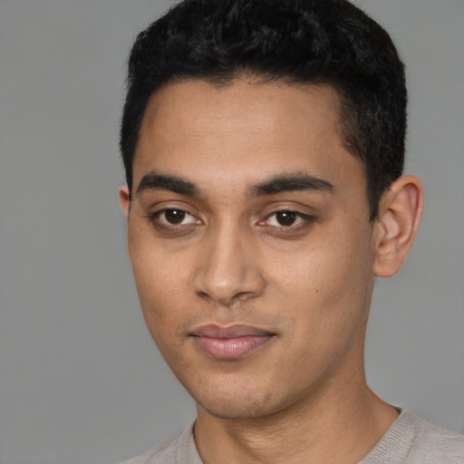 Joyful latino young-adult male with short  black hair and brown eyes