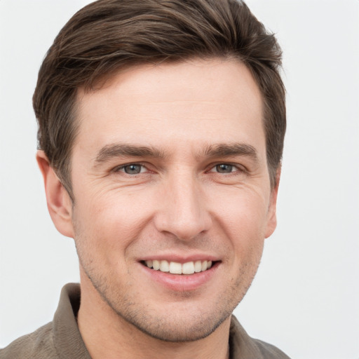 Joyful white young-adult male with short  brown hair and grey eyes