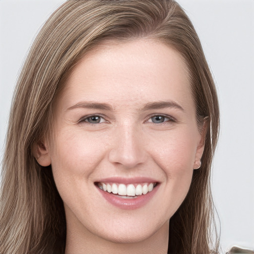 Joyful white young-adult female with long  brown hair and grey eyes