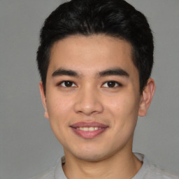 Joyful latino young-adult male with short  brown hair and brown eyes