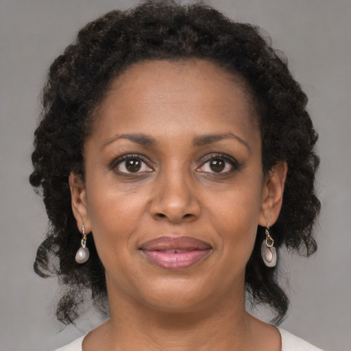 Joyful black adult female with medium  brown hair and brown eyes
