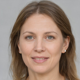 Joyful white adult female with medium  brown hair and grey eyes