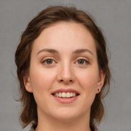 Joyful white young-adult female with medium  brown hair and green eyes