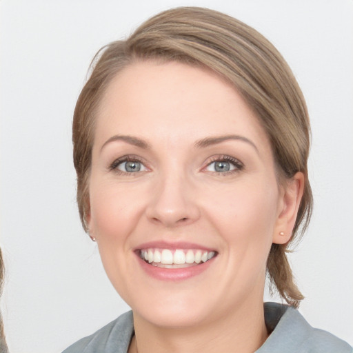 Joyful white young-adult female with medium  brown hair and green eyes